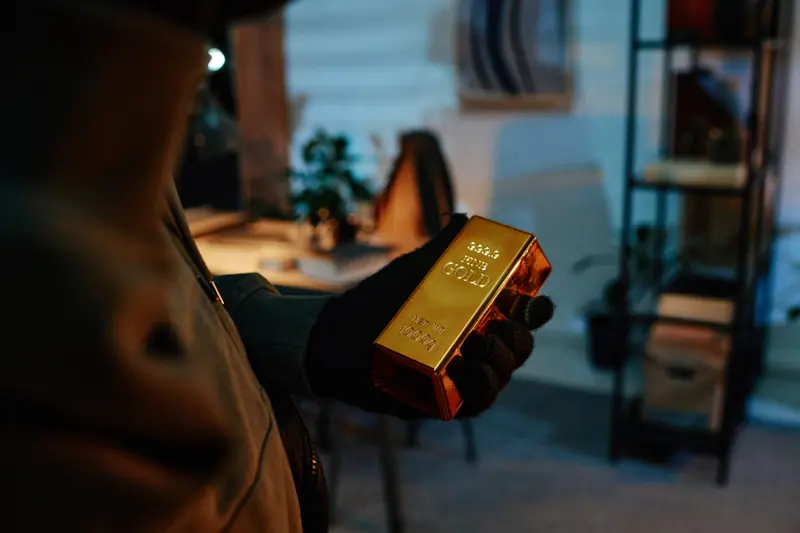 Lingot d’or pur reposant sur un socle minéral dans un coffre feutré.
